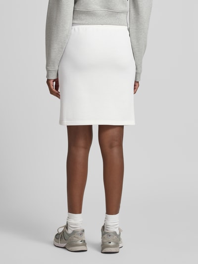 Vrouwenmodel draagt Sweatrock mit Label-Stitching van Gant in wit, rechte fit, katoenmix, elastische taille met tunnelkoord, minirok, detailopname achteraan.