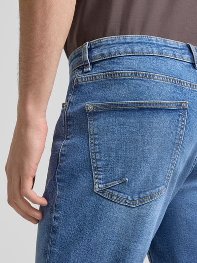 Männermodel trägt Slim Fit Jeansshorts mit Umschlag von REVIEW im Baumwoll-Elasthan-Mix, blaue Waschung, Nahaufnahme Rückansicht.