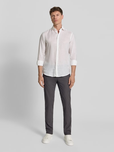 Männermodel trägt Regular Fit Hose mit 5-Pocket-Design aus Baumwoll-Mix Modell 'Cadiz' von Brax, unifarben, Ganzkörperansicht von vorne.