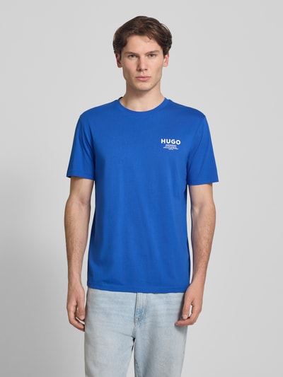 Męski model nosi Regular Fit T-Shirt aus reiner Baumwolle Modell 'NESPTEE' von HUGO w kolorze niebieskim, gładka faktura, męski t-shirt od HUGO, Ganzkörperansicht von vorne.