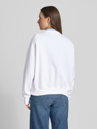 Vrouwenmodel draagt Oversized Sweatshirt aus Baumwoll-Mix van Polo Ralph Lauren in effen wit, lange mouwen, ronde hals, ribboorden, katoenmix, oversized fit, logo detail, sweatstof, volledige lichaamsweergave achterkant.