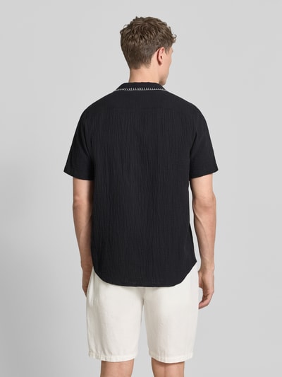 Männermodel trägt Regular Fit Freizeithemd aus reiner Baumwolle Modell 'ELLINO' van HUGO, uni zwart, contrastnaad, resortkraag, korte mouw, volledig knoopsluiting, context: herenoverhemd, materiaal katoen, achteraanzicht volledige lichaamsopname.
