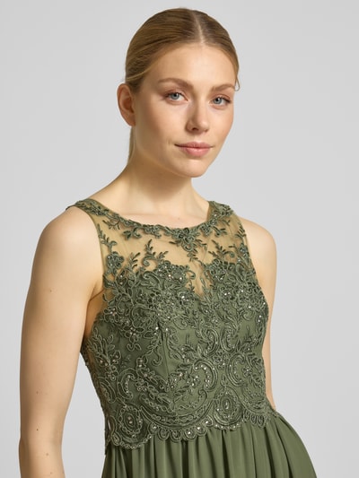 Frauenmodel trägt Midikleid mit Spitze und Ziersteinbesatz von Laona in Olivgrün, feine Chiffon-Textur, Detailnahaufnahme Oberkörper, A-Linie, Rückreißverschluss, Spitzenverzierung, Kontext: Rückenlänge 123 cm, Brustweite 32 cm bei Größe 36.