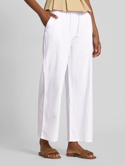 Vrouwenmodel draagt witte, wide leg stoffen broek van puur katoen, elastische band met tunnelkoord, model 'CISSIE' van Soyaconcept, dames, verkorte pasvorm, context: bandwijdte maat S 37 cm, binnenbeenlengte 73 cm, detailopname bovenbenen vooraan.