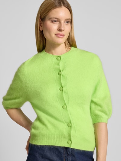 Frauenmodel trägt Strickjacke aus Kaschmir-Baumwoll-Mix mit 1/2-Arm von HERZENS, Regular-Fit, Rundhalsausschnitt, Knopfleiste, leuchtend grün, Feinstrick, Ganzkörperansicht von vorne.