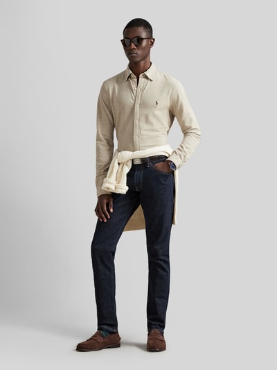 Mannenmodel draagt Regular Fit vrijetijdsoverhemd uit zuiver katoen van Polo Ralph Lauren in effen kleuren piqué structuur, knoopsluiting, button-downkraag, lange mouw met sportmanchet, gestikt logo, frontale full-body shot.