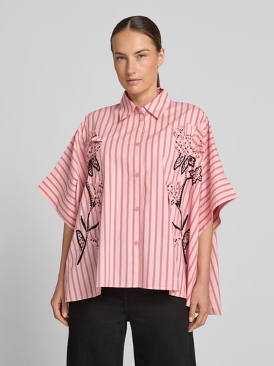 Frauenmodel trägt Oversized Kurzarmbluse aus reiner Baumwolle Modell 'JONKOE' von Essentiel Antwerp, rosa mit Streifen und floralem Muster, Ganzkörperansicht von vorne. Damen Kurzarmbluse von Essentiel Antwerp.