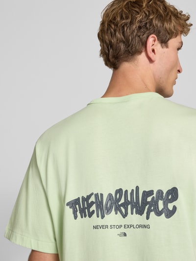 Männermodel trägt Relaxed Fit T-Shirt aus puur katoen met logoprint van The North Face in lichtgroen, ronde hals, ruglengte maat M 72 cm, detailaufnahme rug