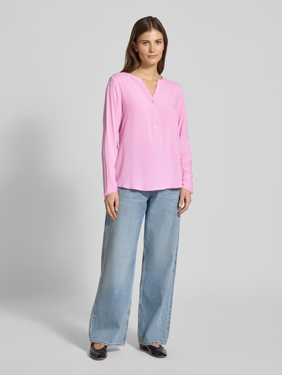 Vrouwenmodel draagt Regular Fit Blouse uit zuivere viscose met tuniekhals van Christian Berg Woman, effen roze, knoopsluiting, met lange mouwen, vooraanzicht volledig lichaam.