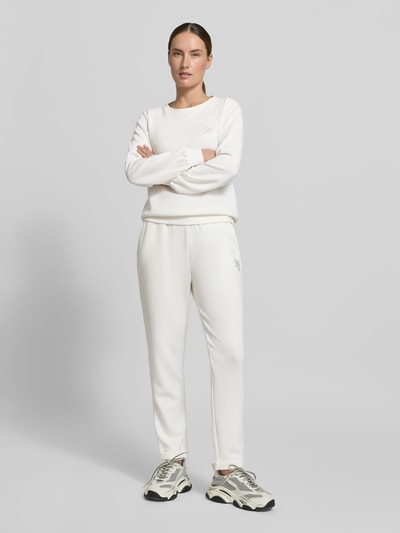 Frauenmodel trägt Sweatpants mit elastischem Bund und Logo von LIU JO SPORT, Weiß, Modal-Mix mit Stretch-Anteil, Regular-Fit, Ganzkörperansicht von vorne.