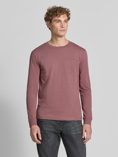 Męski model nosi Regular Fit T-Shirt aus reiner Baumwolle Modell 'solid' von Tom Tailor Denim w kolorze brudnego różu, prosta forma, gładka tekstura, Ganzkörperansicht von vorne