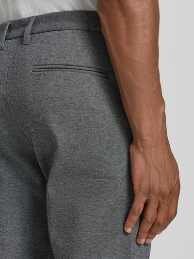 Mężczyznamodel nosi Slim Fit Hose mit Viskose-Anteil in verkürzter Passform od Lindbergh, szara mieszanka wiskozy, kieszeń z tyłu, krój slim fit, skrócony fason, wpuszczane kieszenie, zapięcie na guzik i zamek błyskawiczny, szerokość w rozmiarze M: 42 cm, długość wewnętrzna nogawki w rozmiarze M: 72 cm, zdjęcie: zbliżenie na tył spodni