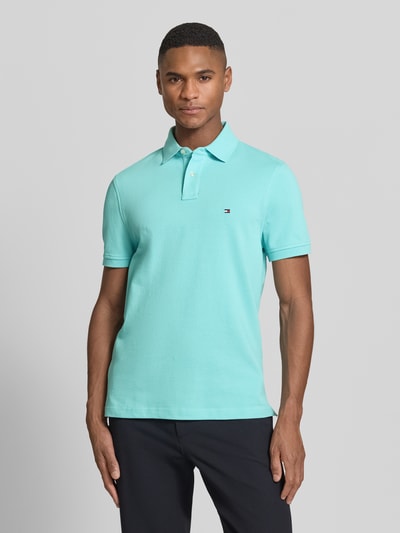 Männermodel trägt Regular Fit Poloshirt aus Baumwoll-Mix von Tommy Hilfiger, Optik: Unifarben, Logo-Stitching, Polokragen, Piqué, Nahaufnahme Oberkörper.