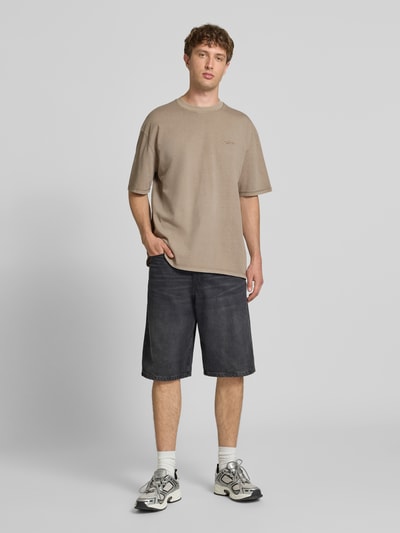 Męski model nosi Oversized T-Shirt mit Label-Stitching od Pegador, bawełna, krój oversized, okrągły dekolt, długość tyłu M: 70 cm, widok całej sylwetki z przodu.
