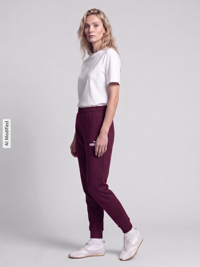Frauenmodel trägt Sweatpants mit Label-Stitching und elastischem Bund von PUMA in Dunkelrot, Baumwoll-Mix, Relaxed Fit, Ganzkörperansicht Vorderansicht, KI-modifiziertes Bild.