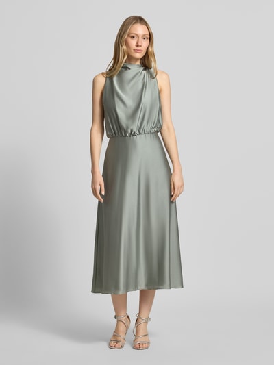 Frauenmodel trägt Cocktailkleid mit Stehkragen von Swing in zartem Mintgrün, taillierte Passform, Midikleid, Ganzkörperansicht von vorne.