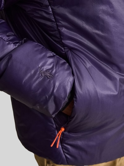 Männermodel trägt Bomberjacke mit Reißverschlusstaschen von POLO RALPH LAUREN in Unifarben, glänzende Struktur, Nahaufnahme Oberkörper.