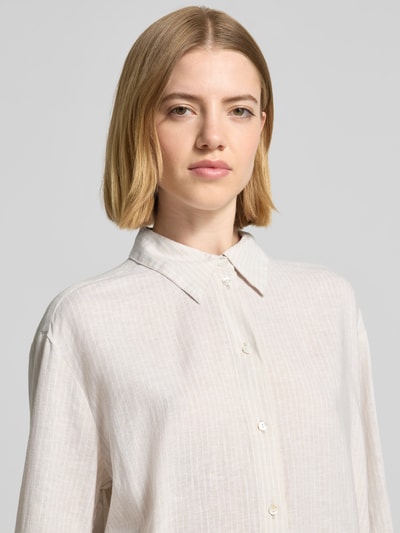 Vrouwenmodel draagt Oversize Langarmbluse aus Leinen-Viskose-Mix van Tom Tailor, lichte kleur met all-over motief, mix van linnen en viscose, overhemdkraag, knoopsluiting, oversized pasvorm, lange mouw, nahaufnahme bovenlichaam.