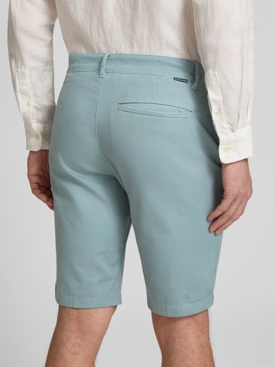 Männermodel trägt Slim Fit Chinoshorts aus reiner Baumwolle von Tom Tailor, Optik: Unifarben, Passform: Slim-Fit, Paspeltaschen hinten, Ganzkörperansicht Rückansicht.