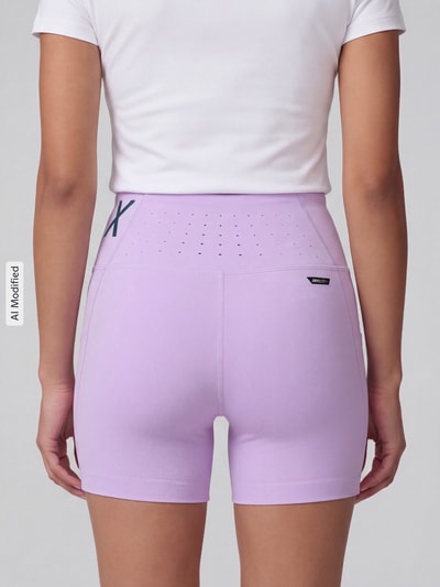 Frauenmodel trägt lilafarbene Skinny Fit Sportshorts mit Label-Print Modell 'PUMA x HYROX PWRMODE 4' von PUMA, Damen Sportshorts, Ganzkörperansicht Rückansicht, KI-modifiziertes Bild.