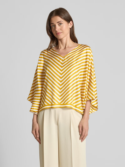 Frauenmodel trägt Bluse aus Seide mit V-Ausschnitt von Windsor in Gelb-Weiß mit Streifen, Loose Fit, Fledermausärmel, Nahaufnahme Oberkörper.
