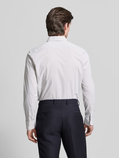 Männermodel trägt Regular Fit Businesshemd mit Kentkragen Modell 'JOE' von BOSS, weiß mit feinem Allover-Streifendesign in Webstruktur, Ganzkörperansicht Rückansicht.