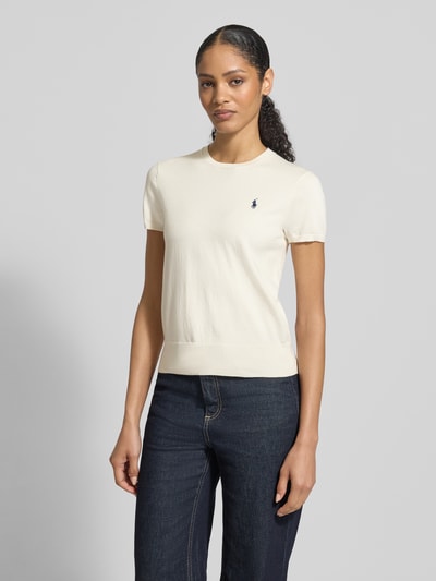 Frauenmodel trägt Regular Fit Kurzarmpullover aus Baumwoll-Mix von Polo Ralph Lauren mit Logo-Stitching, Rundhalsausschnitt, elastischen Ärmelabschlüssen, in Creme mit glatter Textur, Ganzkörperansicht von vorne.