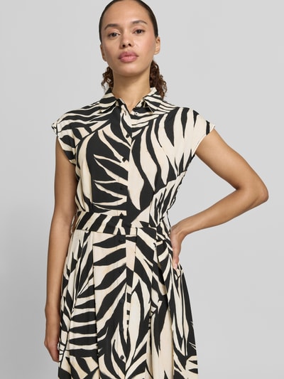 Frauenmodel trägt Hemdblusenkleid aus Viskose mit Bindegürtel Modell 'APPLE' von Mango mit schwarz-beigem Zebramuster, taillierter Schnitt, Hemdblusenkragen, Knopfleiste, Kappärmel, Midilänge, strukturierte Oberfläche, Ganzkörperansicht von vorne.