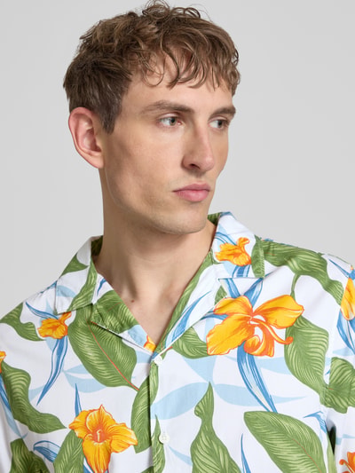 Männermodel trägt Regular Fit Freizeithemd mit Reverskragen von Superdry, tropisches Blumenmuster, Reine Baumwolle, Nahaufnahme Oberkörper. Rückenlänge bei Größe M: 66 cm, Schulterbreite bei Größe M: 41 cm, Ärmellänge bei Größe M: 18 cm.
