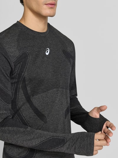 Männermodel trägt Longsleeve mit Logo-Print und Rundhalsausschnitt von ASICS, dunkelgrau mit schwarzen Details, Nahaufnahme Oberkörper, Modell ROAD SEAMLESS, gerader Schnitt, Rückenlänge 70 cm bei Größe M.