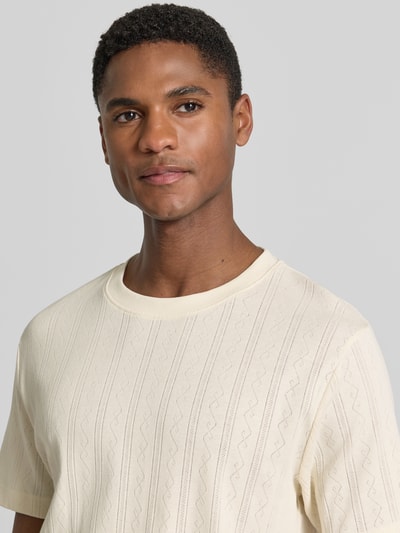 Männermodel trägt T-Shirt in Jaquard-Strick mit Rundhalsausschnitt von Lindbergh, Reine Baumwolle, Regular-Fit, Label-Detail, Nahaufnahme Oberkörper.