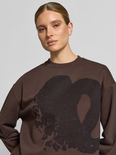 Vrouwenmodel draagt Oversized Sweatshirt uit katoen van Lala Berlin, motiefprint, ronde hals, geribde boorden, donkerbruin, Nahaufnahme bovenlichaam