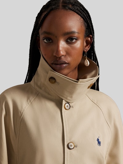 Vrouwenmodel draagt Regular Fit Trenchcoat uit pure katoen van Polo Ralph Lauren in effen beige met logodetail, close-up bovendelig