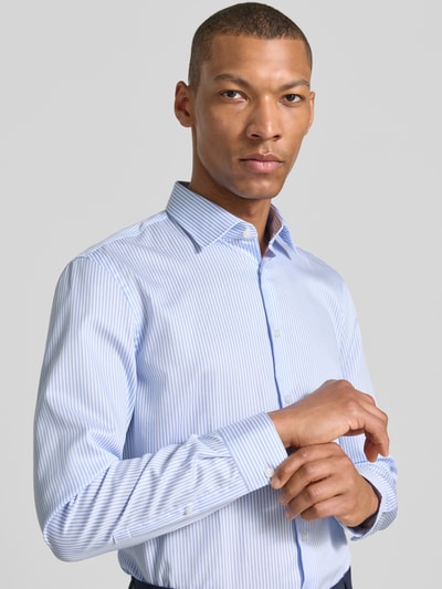 Männermodel trägt Slim Fit Business-Hemd mit Kentkragen von Jake*s, Reine Baumwolle, hellblau gestreift, Nahaufnahme Oberkörper.