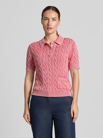 Frauenmodel trägt Slim Fit Poloshirt aus reiner Baumwolle von Jake*s Casual in Rosa mit Zopfmuster, strukturierte Textur, Nahaufnahme Oberkörper.