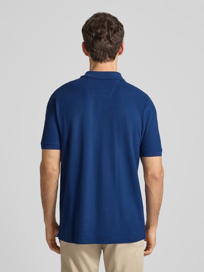 Männermodel trägt Regular Fit Poloshirt mit Label-Stitching von Fynch-Hatton aus reiner Baumwolle, Rückenlänge 74 cm, Ganzkörperansicht Rückansicht.