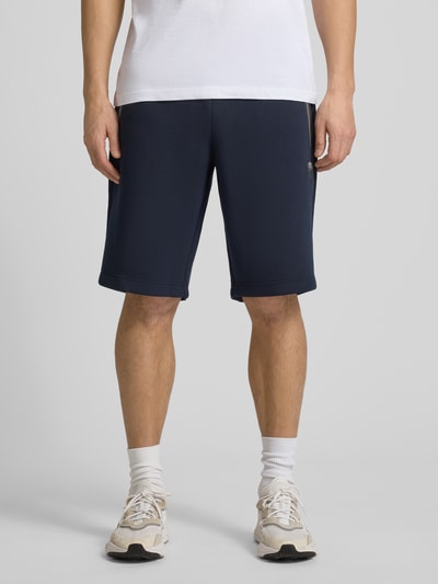 Männermodel trägt Shorts mit elastischem Bund von EA7 Emporio Armani in Dunkelblau, Material-Mix, Regular Fit, Ganzkörperansicht von vorne.