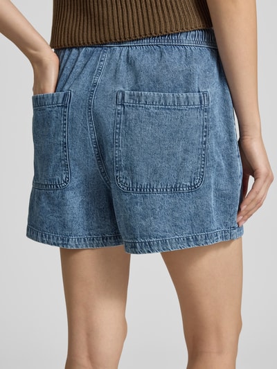 Frauenmodel trägt Shorts mit elastischem Bund Modell 'ENZA' von Noisy May aus Reine Baumwolle, Regular-Fit, blauer Denim-Optik, Ganzkörperansicht Rückansicht. Bundweite bei Größe S: 36 cm, Innenbeinlänge bei Größe S: 8 cm.