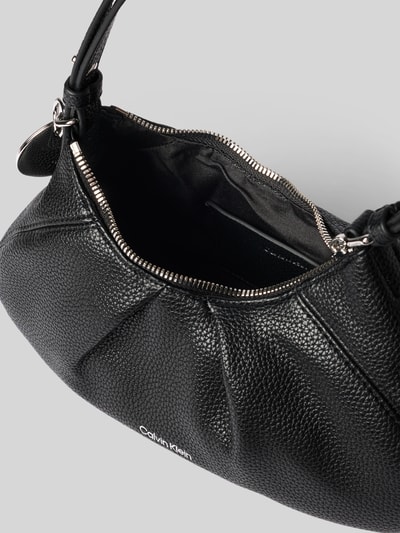 Produktfoto, schwarze strukturierte Henkeltasche mit silbernem Reißverschluss, Prägung Modell 'ENGRAVED HW SMALL BAG' von CK Calvin Klein, Damen Henkeltasche