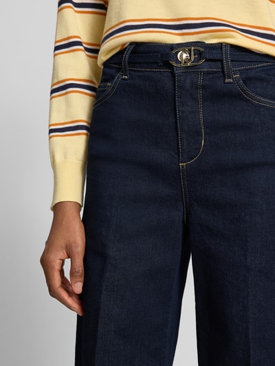Vrouwenmodel draagt Flared Fit Jeans uit katoenmix van Liu Jo White met logodetail en 5-pocketmodel, donkerblauw, detailopname taille
