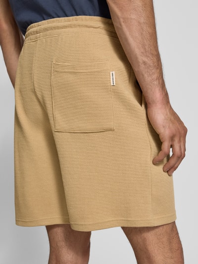 Männermodel trägt Shorts aus Baumwoll-Mix mit Strukturmuster Modell 'KNOX' von Redefined Rebel in Beige, Relaxed Fit, Ganzkörperansicht Rückansicht.