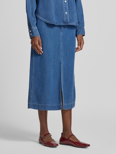 Frauenmodel trägt Jeansrock mit Knopf- und Reißverschluss Modell 'SATOVES' von Samsøe Samsøe aus blauem Lyocell, A-Linie, Midirock, Nahaufnahme Unterkörper.