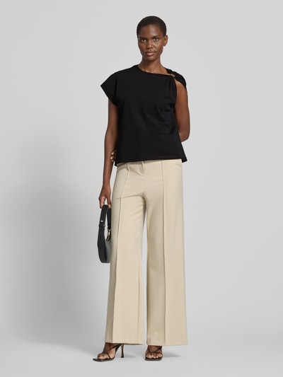 Frauenmodel trägt Damen T-Shirt im One-Shoulder-Look Modell 'ALLIA' von Bash aus reiner Baumwolle, Regular-Fit, schwarze Farbe, Ganzkörperansicht von vorne. Rückenlänge bei Größe S: 58 cm.