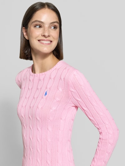 Modelka kobieca ma na sobie Slim Fit Pullover aus reiner Baumwolle von Polo Ralph Lauren w pastelowym różu, delikatna struktura, widoczne pionowe sploty, Nahaufnahme górnej części ciała.