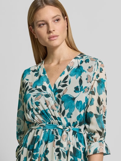 Frauenmodel trägt Midikleid in Wickel-Optik Modell 'Mo44moo' von ZABAIONE aus Chiffon mit Allover-Look, V-Ausschnitt, Bindegürtel; Nahaufnahme Oberkörper. Rückenlänge 120 cm, Brustweite 50 cm, Ärmellänge 46 cm, Größe S.