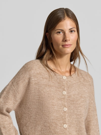 Frauenmodel trägt Regular Fit Cardigan mit Woll-Anteil von MYON, beige Strick-Optik, Rundhalsausschnitt, Nahaufnahme Oberkörper.