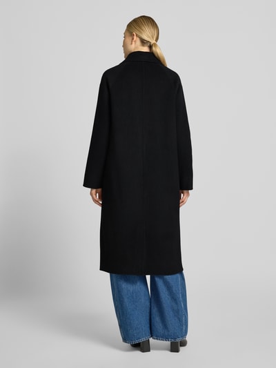 Männermodel trägt Relaxed Fit Mantel aus reiner Wolle mit 2-Knopfleiste von Milano Italy, schwarz, glatte Textur, Ganzkörperansicht Rückansicht. Kontext: płaszcz damski z czystej wełny, krój relaxed fit, kołnierz z klapami, zapięcie na dwa guziki, kieszenie, długość tyłu w rozmiarze 36: 115 cm, szerokość ramion w rozmiarze 36: 45 cm, szerokość klatki piersiowej w rozmiarze 36: 56 cm, długość rękawa w rozmiarze 36: 55 cm.