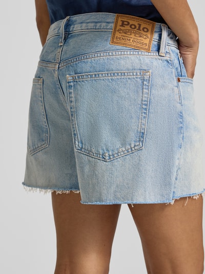 Männermodel trägt Relaxed Fit Bermudas aus reiner Baumwolle von Polo Ralph Lauren, denim hellblau, fransiger Beinabschluss, 5-Kieszeni, label patch; Ganzkörperansicht Rückansicht