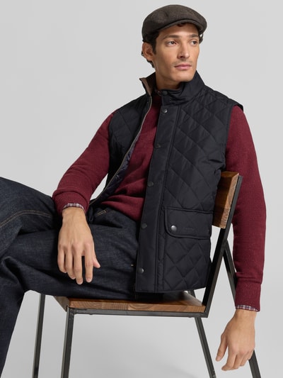 Männermodel trägt schwarze, gesteppte Slim Fit Weste mit Logo-Stitching Modell 'NEW LOWERDALE' von Barbour, Herren Weste, Nahaufnahme Oberkörper.