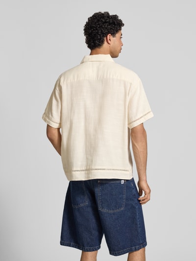 Männermodel trägt Relaxed Fit Freizeithemd aus Lyocell-Mix Modell 'Menton' von Jack & Jones in Beige mit Loch-Stitching, Rückansicht Ganzkörperansicht.